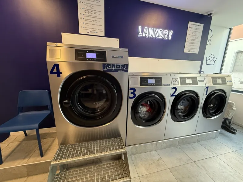 Laveuses numérotées de la laverie Wash’n Dry de Louvres, mur bleu marine